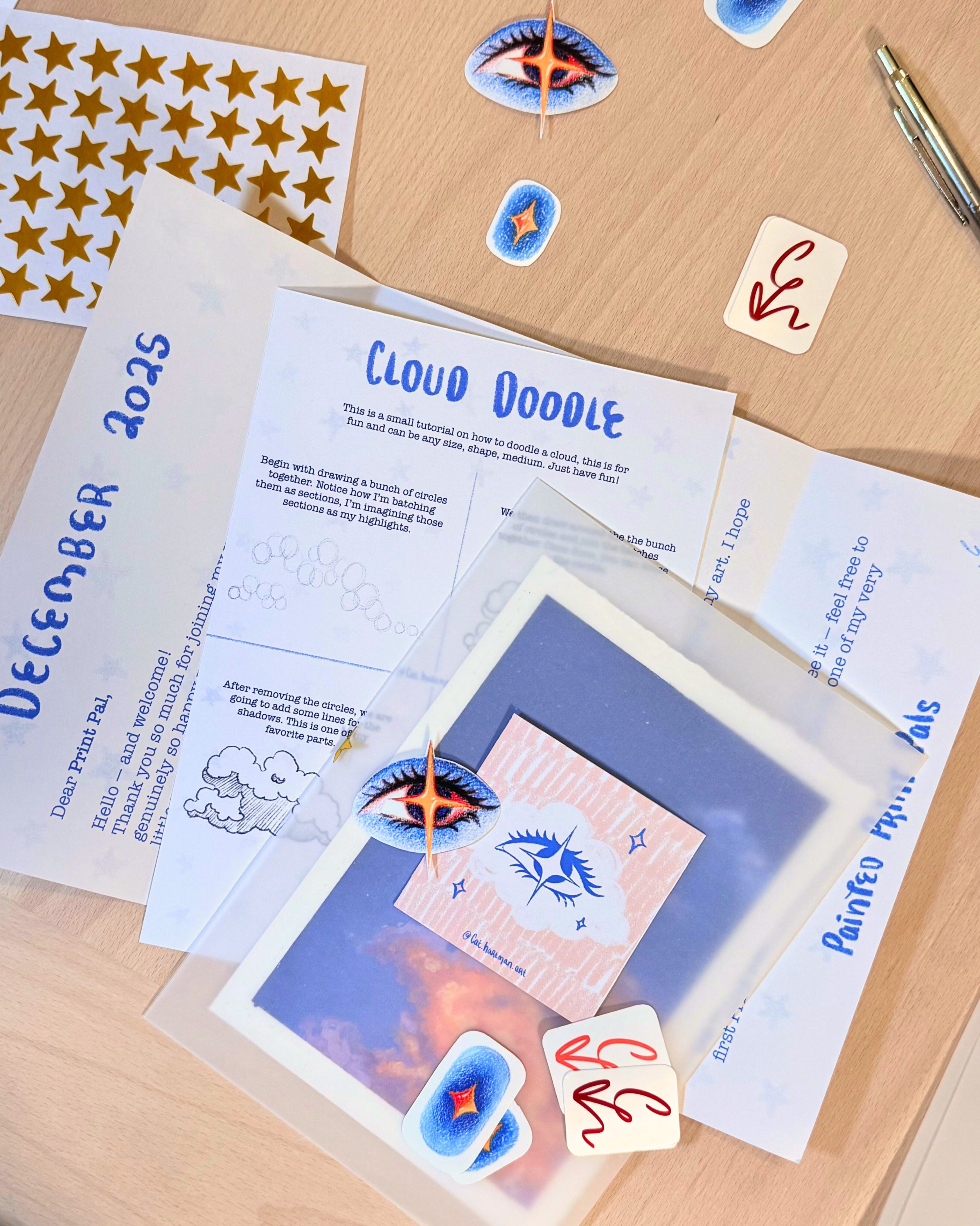 A stack of print club treasures including stickers, art print, a how to draw a cloud card and a letter.